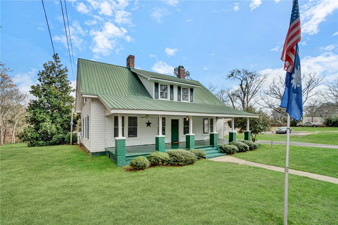302 Gassaway Street Central, SC 29630 - Photo 2 of 34 This charming residence features a classic white facade, a vibrant green roof, and a welcoming front porch.