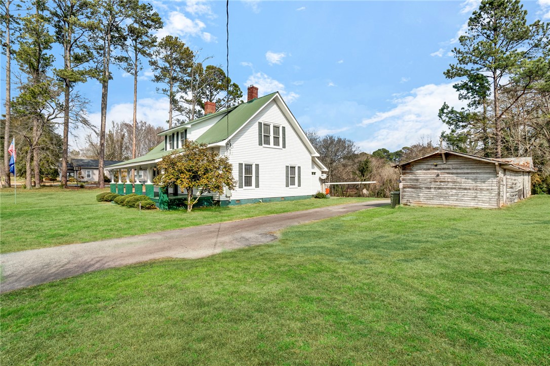 302 Gassaway Street Central, SC 29630 - Photo 28 of 34 This classic white home with a green roof is nestled amidst tall trees, offering a peaceful setting.