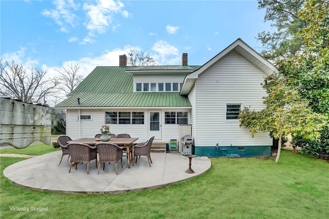 302 Gassaway Street Central, SC 29630 - Photo 29 of 34 VIRTUAL STAGING -This house features a classic green metal roof and a spacious patio for outdoor entertaining.