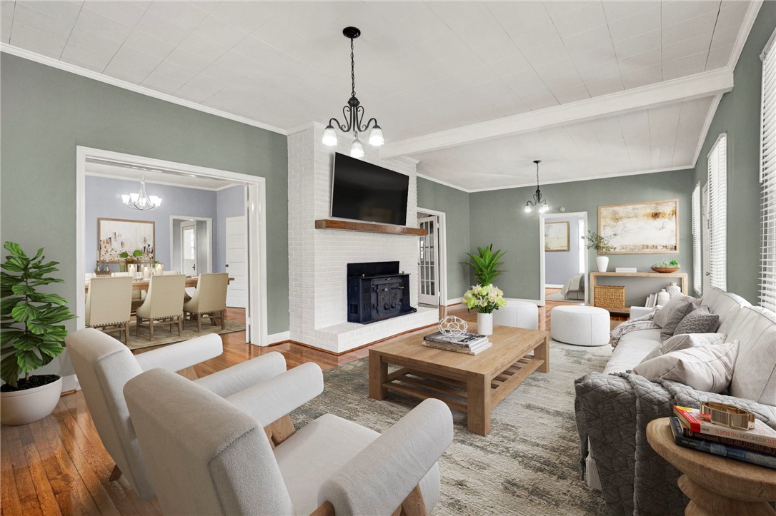 302 Gassaway Street Central, SC 29630 - Photo 3 of 34 VIRTUALLY STAGED - This inviting living space features an exposed brick fireplace, hardwood floors, and elegant lighting.