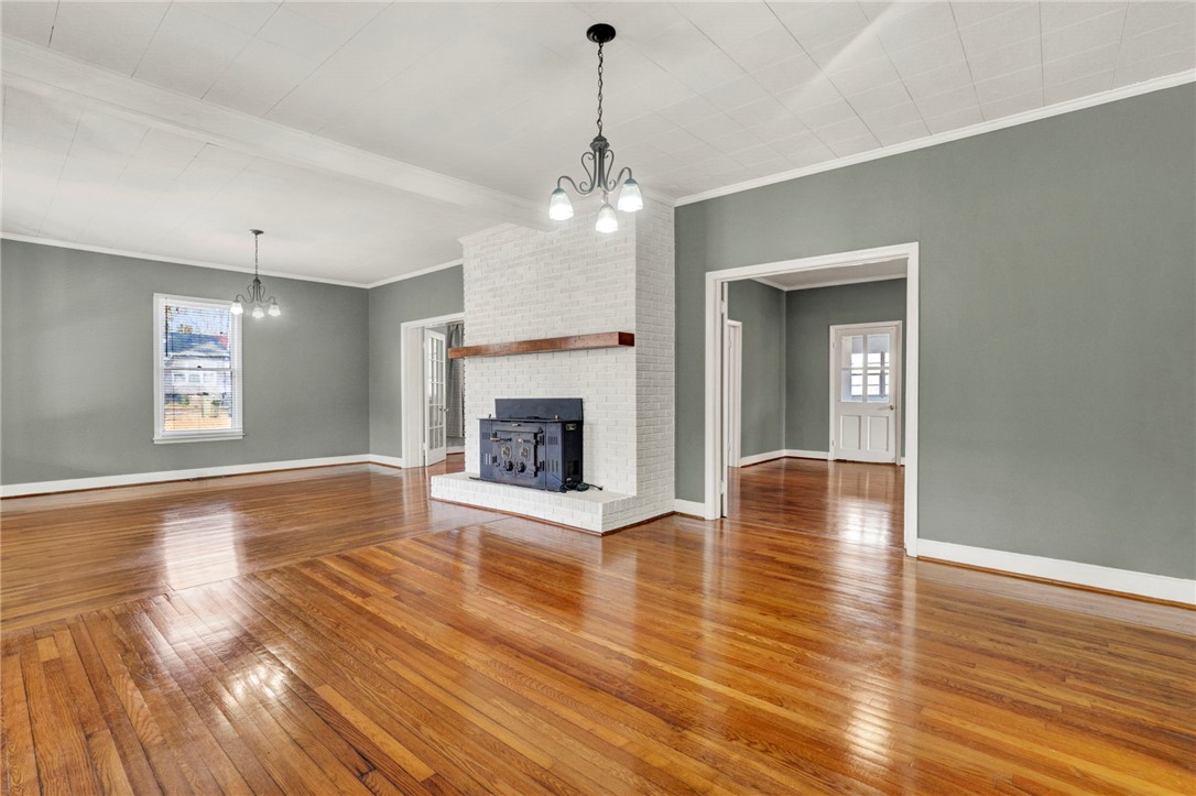 302 Gassaway Street Central, SC 29630 - Photo 4 of 34 This expansive room features beautiful hardwood floors and a striking fireplace, creating a warm and inviting atmosphere.