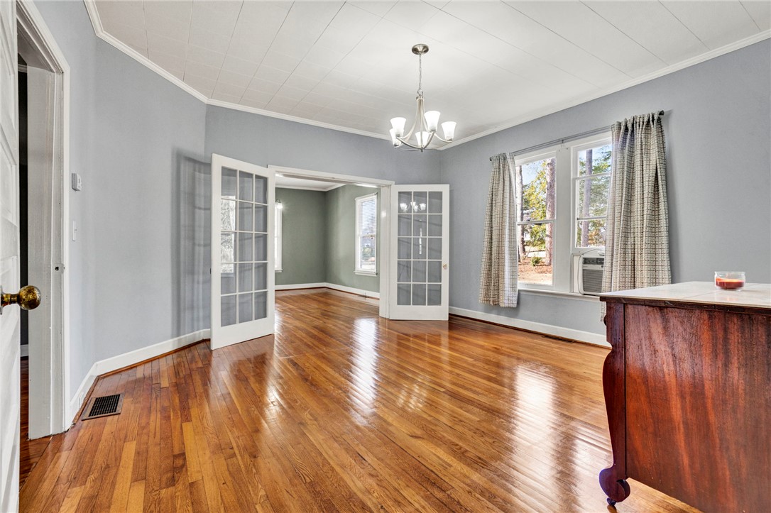 302 Gassaway Street Central, SC 29630 - Photo 6 of 34 This bright dining room features glossy hardwood floors and elegant French doors, creating an inviting space.