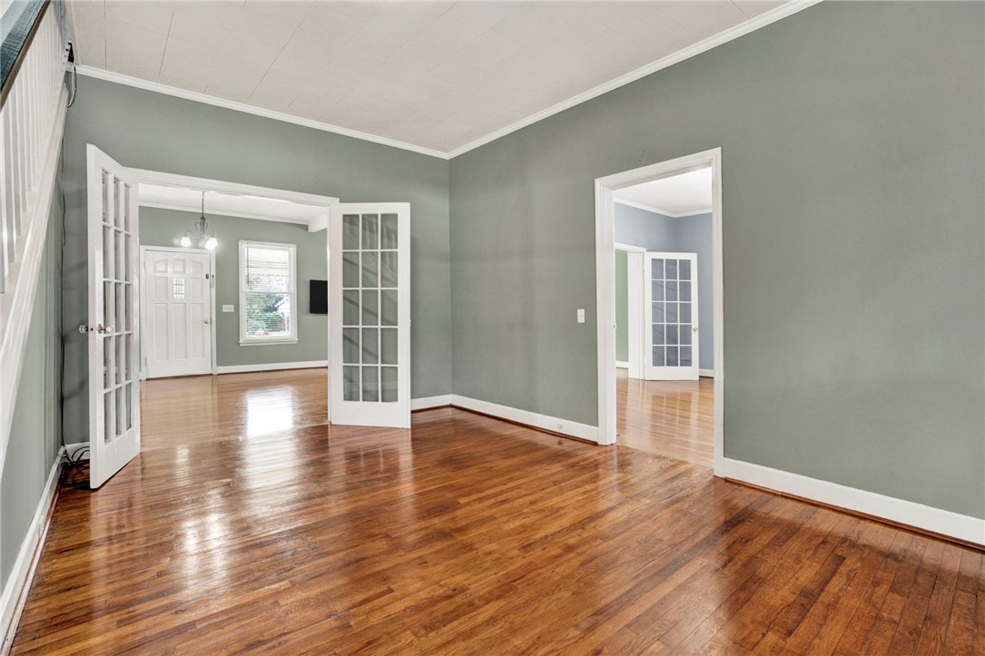 302 Gassaway Street Central, SC 29630 - Photo 9 of 34 This interior space showcases gleaming hardwood floors and classic French doors, offering a refined aesthetic.