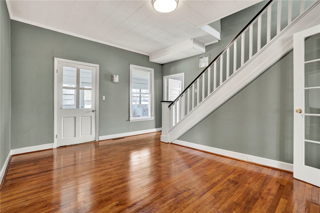 302 Gassaway Street Central, SC 29630 - Photo 10 of 34 This inviting space features lustrous wood floors and a charming staircase, creating a warm and welcoming ambiance.