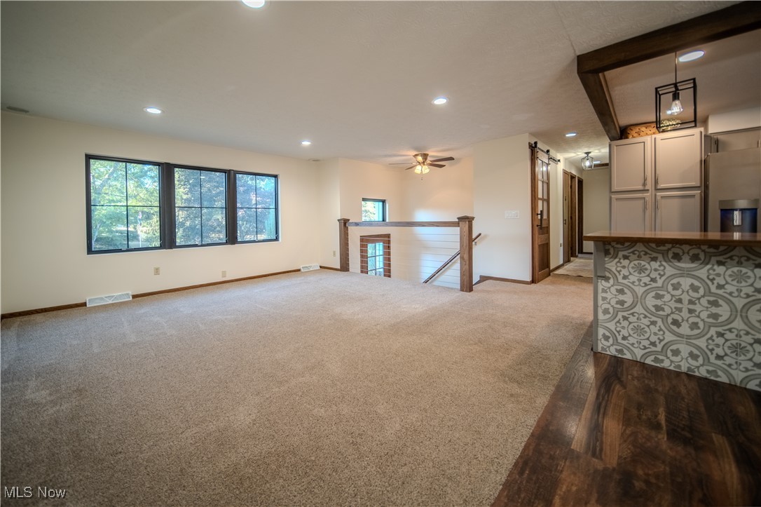 3459 Laubert Road Atwater, OH 44201 - Photo 9 of 39 Empty room featuring a barn door, light colored carpet, recessed lighting, and ceiling fan