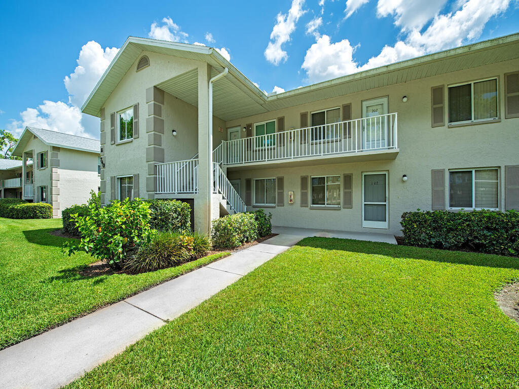 740 Augusta Boulevard, Unit E101 Naples, FL 34113 - Photo 1 of 12 a front view of a house with a yard