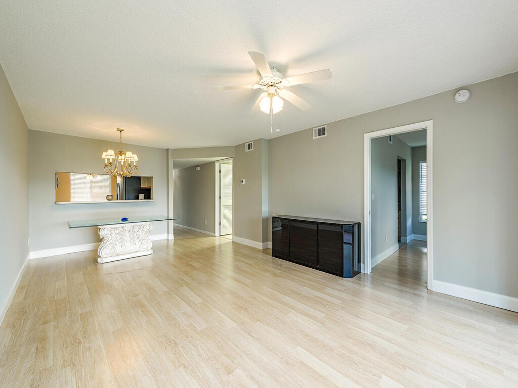 740 Augusta Boulevard, Unit E101 Naples, FL 34113 - Photo 3 of 12 a living room with furniture and a wooden floor