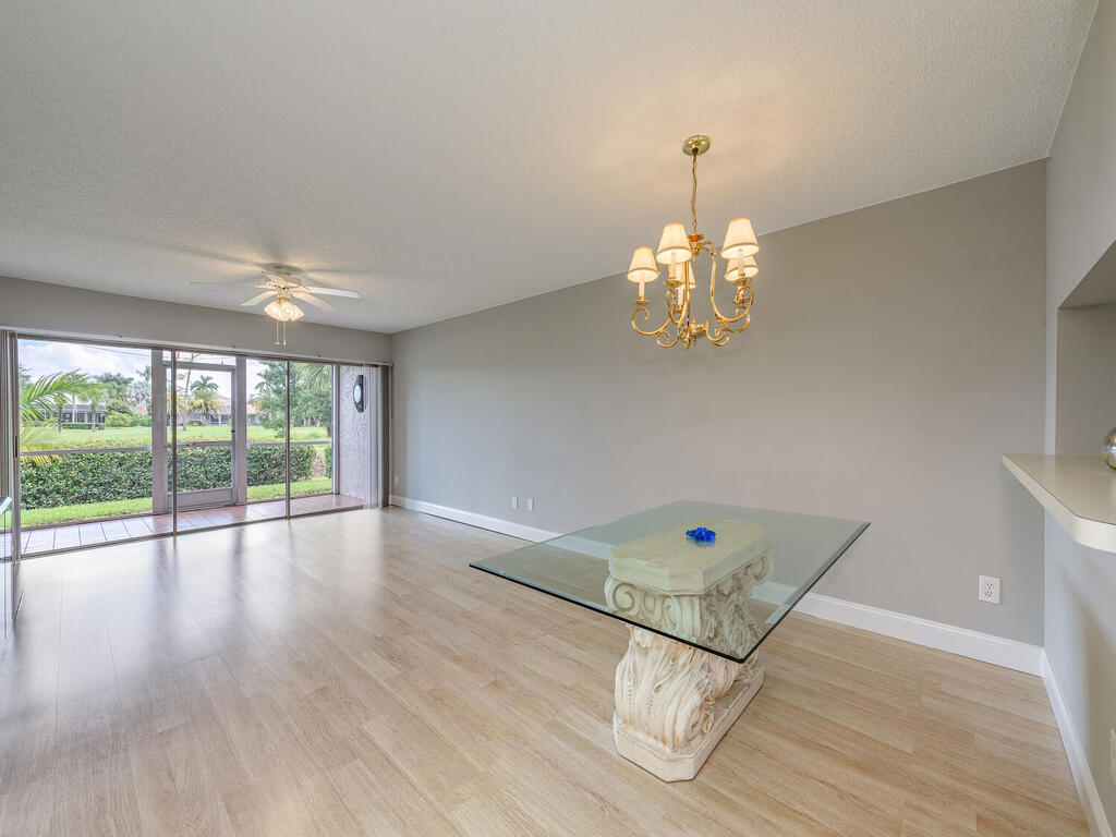 740 Augusta Boulevard, Unit E101 Naples, FL 34113 - Photo 4 of 12 wooden floor in an empty room with a window