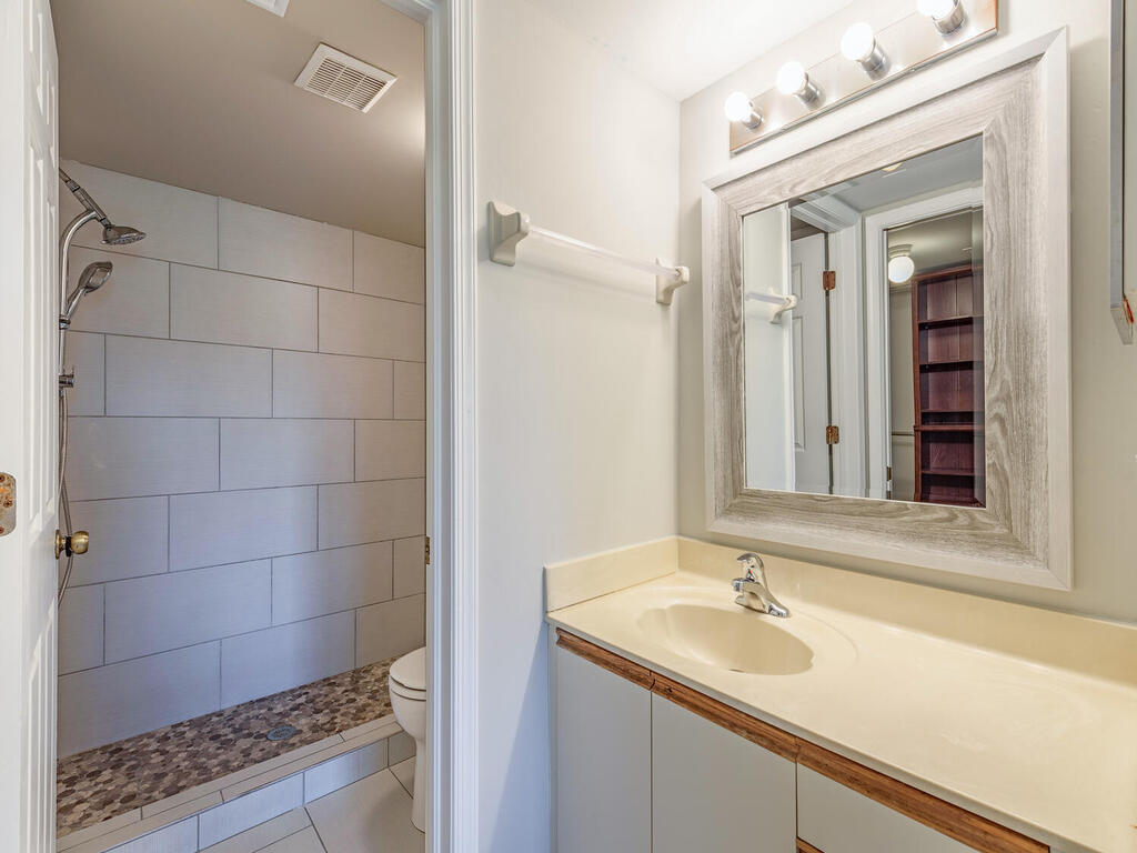 740 Augusta Boulevard, Unit E101 Naples, FL 34113 - Photo 8 of 12 a bathroom with a sink and a mirror