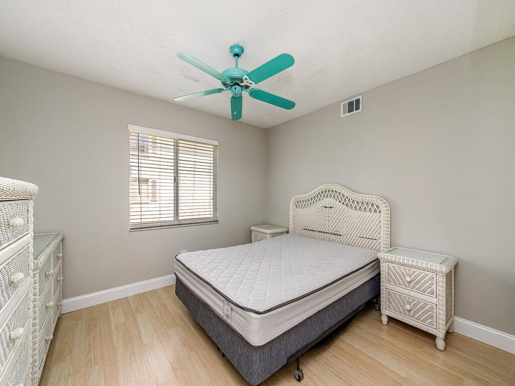 740 Augusta Boulevard, Unit E101 Naples, FL 34113 - Photo 10 of 12 a bedroom with a bed table and a window