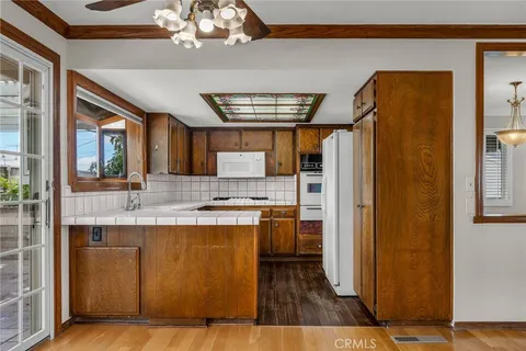 a kitchen with kitchen island granite countertop wooden cabinets and a refrigerator