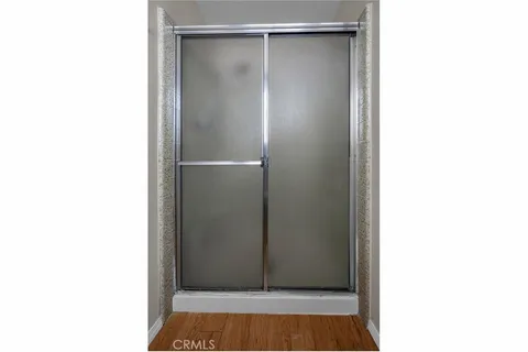 a view of room with walk in closet and wooden floor