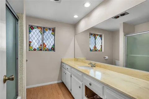 a spacious bathroom with a granite countertop sink a large mirror and a shower