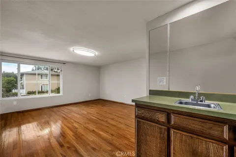 a view of kitchen with granite countertop window and wooden floor
