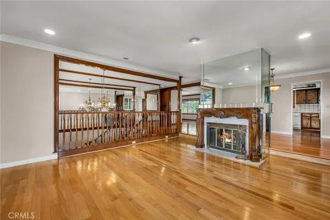 a big room with wooden floor fireplace and windows