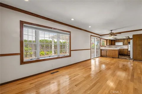 a view of an empty room with a window and wooden floor