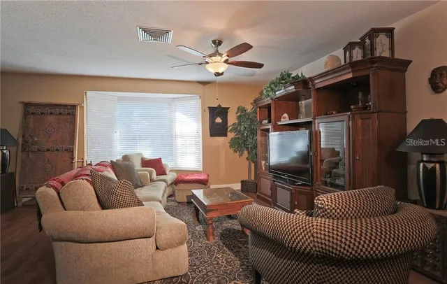 a living room with furniture a ceiling fan and a window