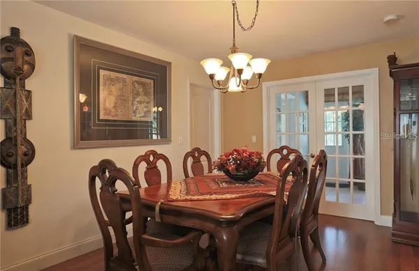 a view of a dining room with furniture wooden floor and chandelier