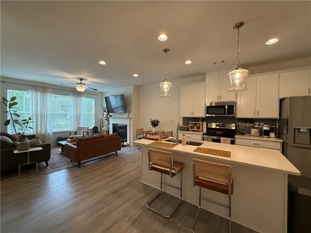 a kitchen that has a lot of cabinets a sink and appliances