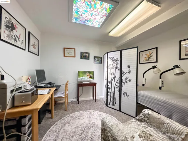 a view of a workspace with furniture and a window