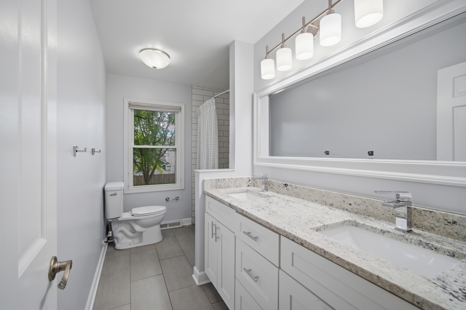 2831 Farmington Road Northbrook, IL 60062 - Photo 21 of 33 a bathroom with a granite countertop toilet a sink and a mirror