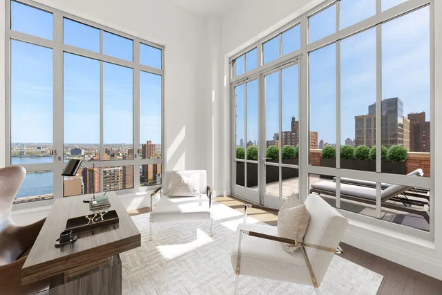 a living room with furniture and large windows