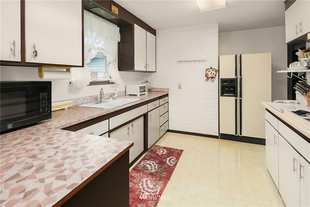 859 Monroe Avenue Northeast Renton, WA 98056 - Photo 11 of 23 a kitchen with stainless steel appliances granite countertop a sink stove and refrigerator
