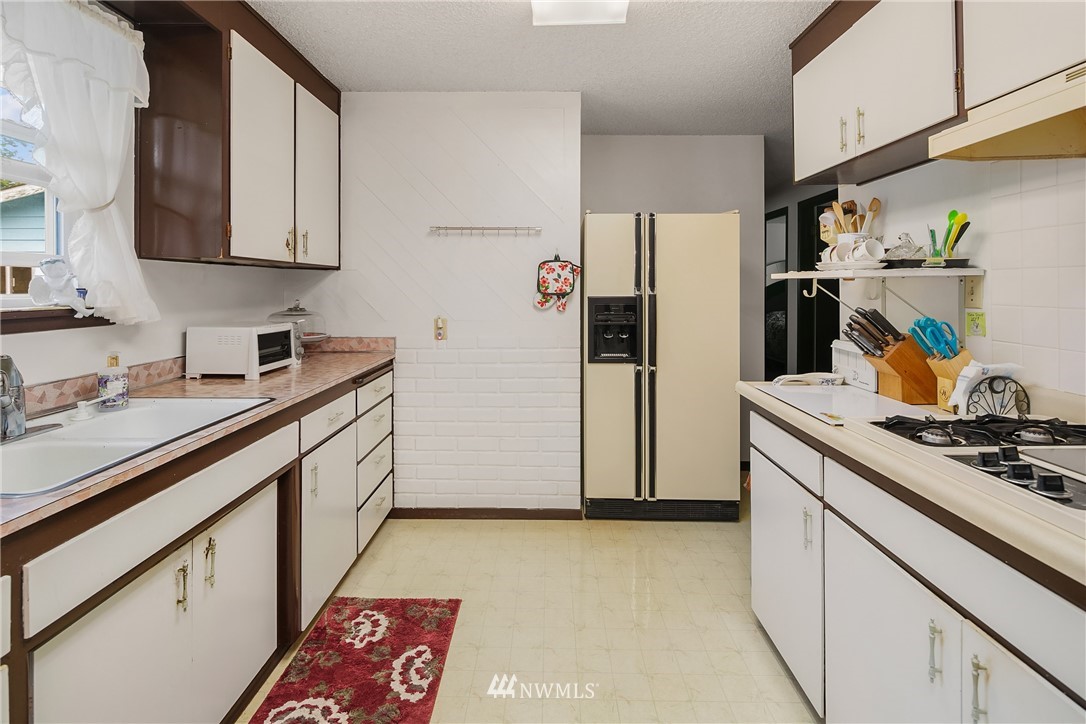 859 Monroe Avenue Northeast Renton, WA 98056 - Photo 12 of 23 a kitchen with stainless steel appliances granite countertop a refrigerator and a sink