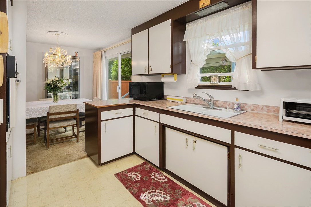 859 Monroe Avenue Northeast Renton, WA 98056 - Photo 13 of 23 a kitchen with a sink stove and cabinets