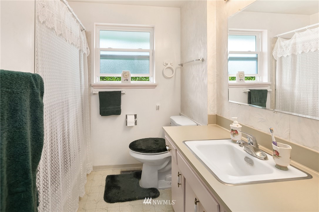 859 Monroe Avenue Northeast Renton, WA 98056 - Photo 17 of 23 a bathroom with a sink toilet and mirror