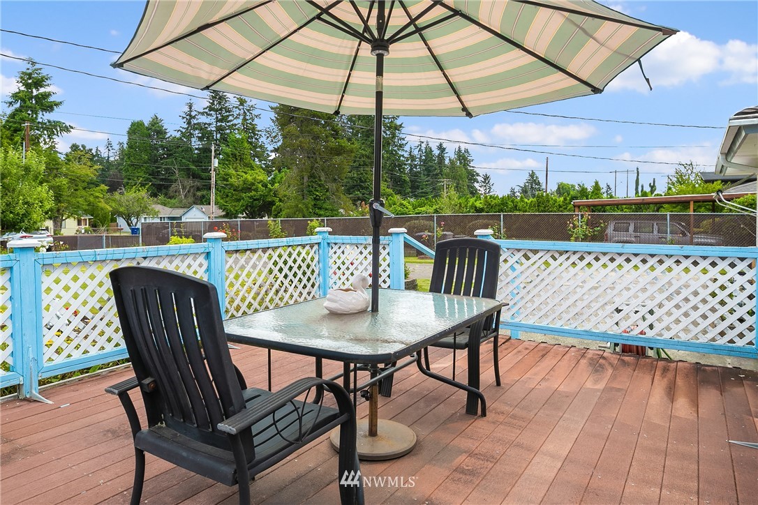 859 Monroe Avenue Northeast Renton, WA 98056 - Photo 7 of 23 a patio with wooden floor a yard a table and chairs