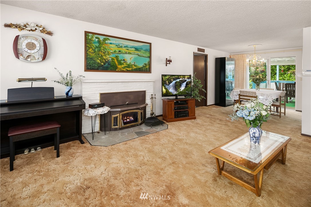 859 Monroe Avenue Northeast Renton, WA 98056 - Photo 8 of 23 a living room with furniture a fireplace and a large window
