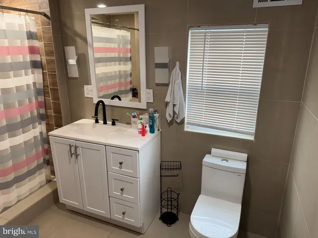 a bathroom with a sink a toilet and a window
