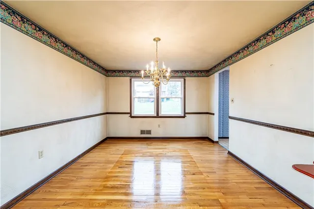 a view of a room with wooden floor and furniture