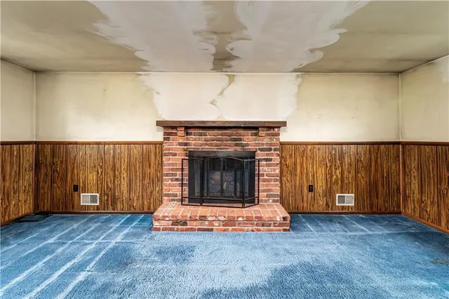 an empty room with windows and fireplace