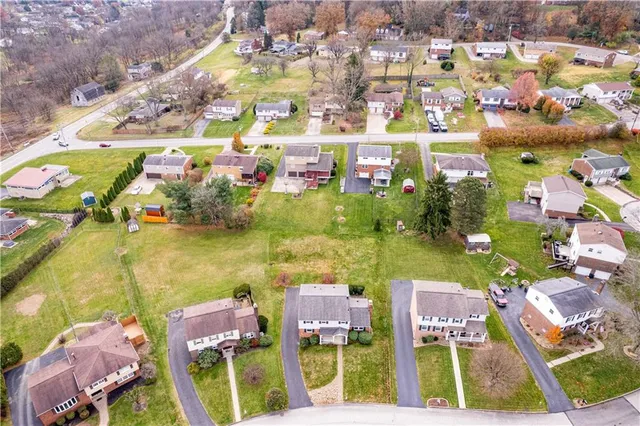 an aerial view of residential houses with outdoor space and swimming pool