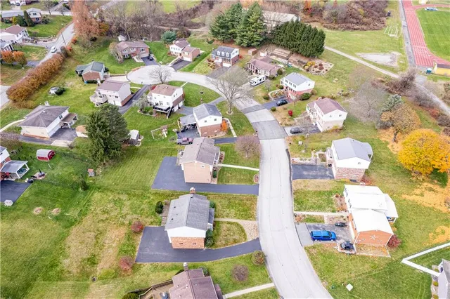 an aerial view of a house with a yard basket ball court and outdoor seating