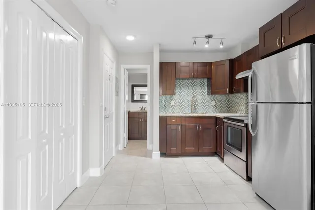 a kitchen with granite countertop a refrigerator and a sink