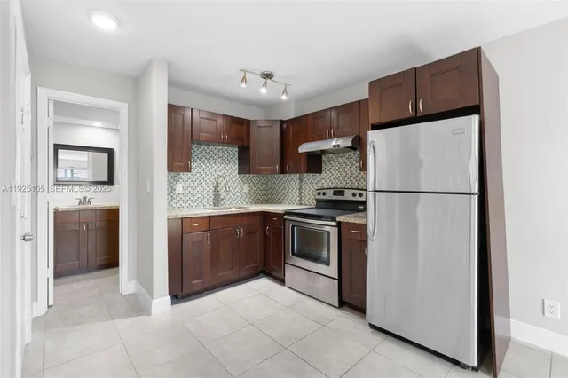 a kitchen with stainless steel appliances granite countertop a refrigerator sink and cabinets