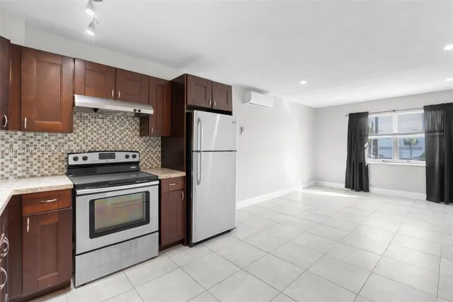 a kitchen with a stove top oven and refrigerator