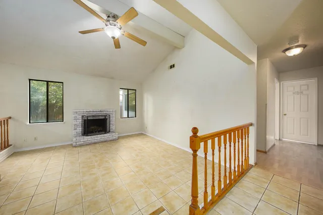 a view of an empty room with a chandelier fan