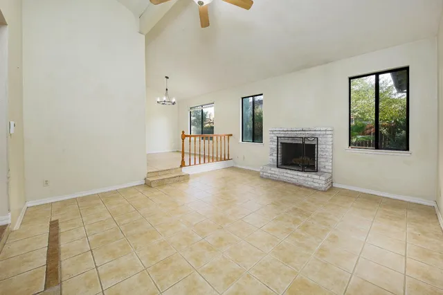 an empty room with a ceiling fan and carpet
