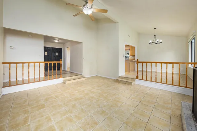 a view of a livingroom with a chandelier fan and windows