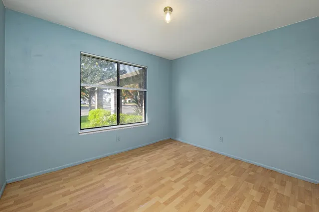 an empty room with closet and a ceiling fan