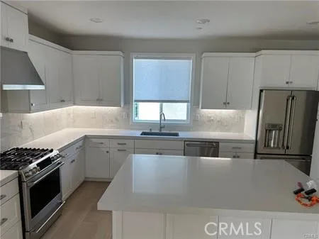 a kitchen with stainless steel appliances granite countertop a stove a sink and a refrigerator