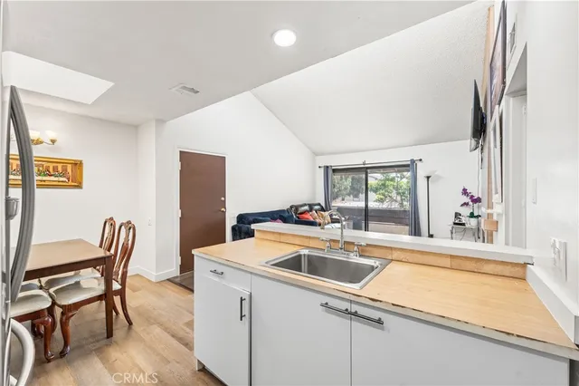 a kitchen that has a sink chairs and a refrigerator