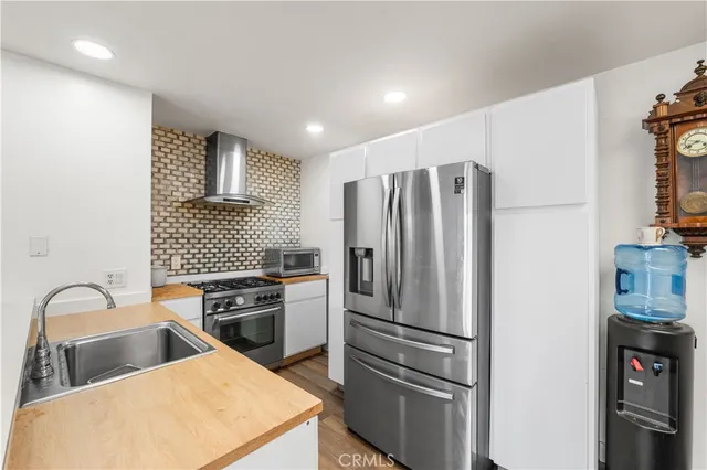 a kitchen with stainless steel appliances a refrigerator and a stove top oven