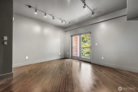 an empty room with wooden floor and windows