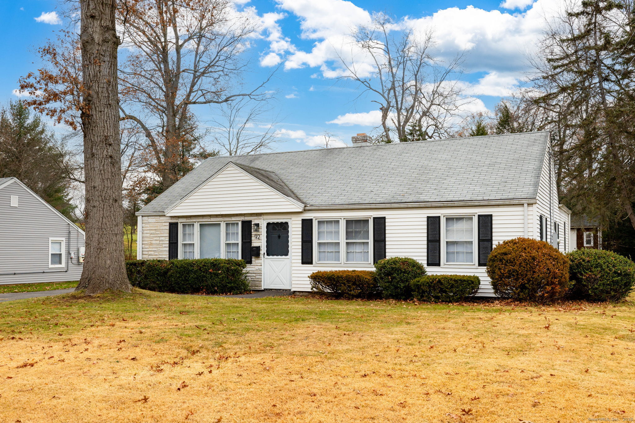 a front view of house with yard and trees around
