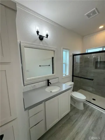 a bathroom with a sink a toilet and shower